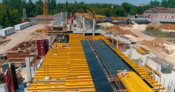 I costruttori realizzano casseforme nel cantiere di un nuovo stadio. Processo di costruzione di un moderno stadio di calcio. Veduta aerea della costruzione in cemento armato — Video Stock