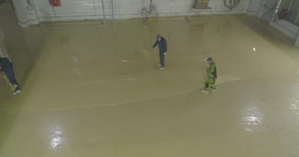 Workers make self-leveling floors. The process of laying the self-leveling floor. Construction site working on the floors — Stock Video