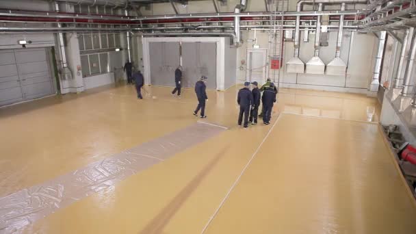 Zelfnivellerende vloer over een groot gebied. Bouwvakkers maken een zelfnivellerende vloer in de werkplaats. Zelfnivellerende vloer in de werkplaats — Stockvideo