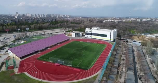 สนามฟุตบอลที่มีลู่วิ่งไปรอบ ๆ สนามฟุตบอลที่มีหญ้าสีเขียวที่สมบูรณ์แบบ . — วีดีโอสต็อก