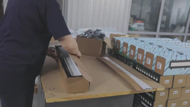 Arbeiter verpacken Fertigprodukte in eine Schachtel. Verpackung von Fertigwaren in einer Schachtel. — Stockvideo