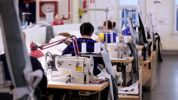 여자들은 바느질하는 기계를 만들기 위해 일한다. 많은 재봉사들은 의류 공장에서 일합니다. 의류 공장에서 일하는 모습. — 비디오