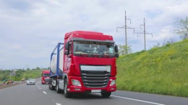 Bir grup kamyon otoyol boyunca gidiyor. Tank kamyonu olan bir kamyon otoyolda gidiyor. Modern kamyonlar sıvı kargoyu tanklarla taşır. Kırmızı kamyon otoyol boyunca gidiyor..