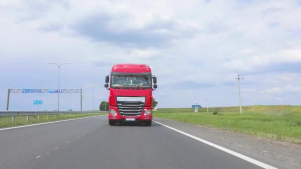 A group of trucks are driving along the highway. A truck with a tank truck drives on the highway. Modern trucks transport liquid cargo in tanks. The red truck is driving along the highway. — Stock Video