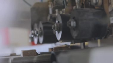 Otomatik bir makine bir tahta parçasını testereyle keser. Otomatik ahşap testeresi. Mobilya üretiminde otomatik hat