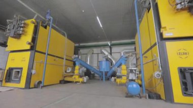 Fabrikadaki modern bir kazan dairesi. Modern bir ahşap talaş sobası. Sanayi ocağı ahşap işçiliğinin atıkları üzerinde çalışıyor. Soba ahşap işçiliğinden gelen atıklarla çalışıyor.