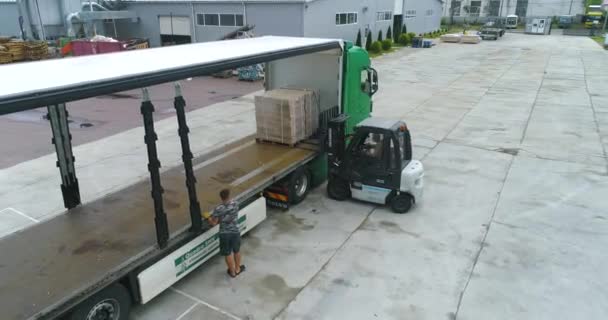 De vorkheftruck laadt de goederen in de truck. workflow in een fabriek. Vrachtvervoer — Stockvideo
