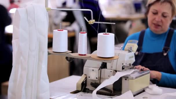 Bir terzi elbise fabrikasında çalışıyor. Tekstil üretimi. Çalışma süreci. Profesyonel ekipman dikiyorum. — Stok video