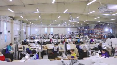 Time laps in the sewing workshop. Women work in a sewing workshop, filming in time laps. Garment factory interior.