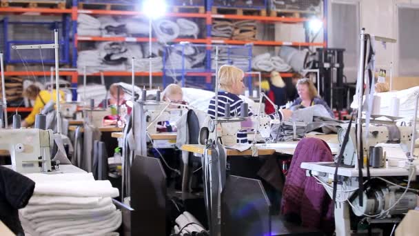 Werken in een naaiatelier. Werkproces in de werkplaats van een kledingfabriek. Naaisters werken in een textielfabriek — Stockvideo