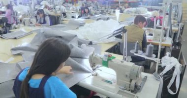 Dikiş fabrikasında çalışan bir terzi. Dikiş üretimi. Ev yapımı tekstil. Büyük dikiş atölyesi