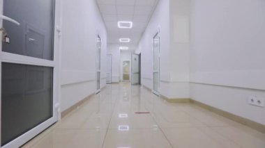 Kamera hastanenin boş koridoru boyunca döner. Modern bir hastanenin koridorları. Kliniğin boş, parlak koridoru. Modern bir kliniğin içinde.