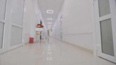 Modern bir kliniğin içinde. Kliniğin boş, parlak koridoru. Modern bir hastanenin koridorları. Kamera hastanenin boş koridoru boyunca dönüyor..