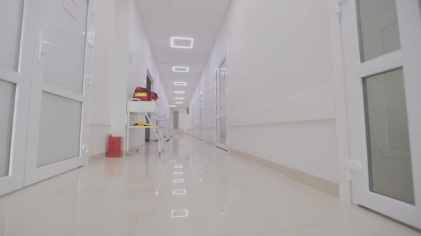 Inredning av en modern klinik. Klinikens tomma, ljusa korridor. Korridorer till ett modernt sjukhus. Kameran skålar längs den tomma hallen på sjukhuset. — Stockvideo