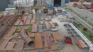 Büyük metal bir boru bir vinç tarafından kaldırılır. Metal yapılar montajı için atölyenin üzerinden uçuyor. Endüstriyel dış görünüş. Üst görünümü yerleştir