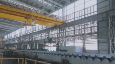 Atölyedeki vinç yükleniyor. Büyük bir atölyede sarılı modern bir vinç. Modern köprü vinci