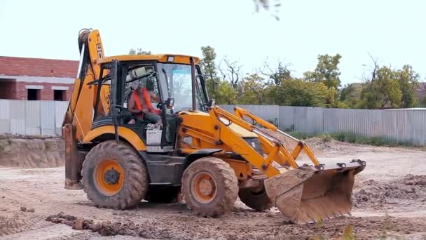 Tracteur jaune sur un chantier. Matériel de construction professionnel. Processus de travail sur un chantier — Video