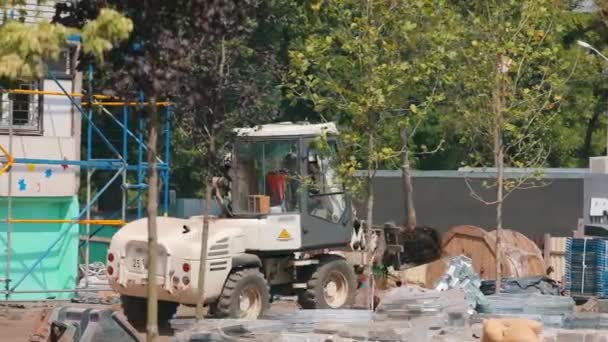 Een vorkheftruck draagt een boom in een pot. Bomen planten in de stad. Groener worden van de stad — Stockvideo