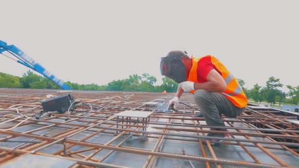 Working process at a construction site. Welder at a construction site. Welder close-up. Metal structures — Stock video