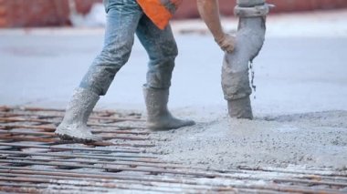 Metal bir yapı için beton dökülüyor. Güçlendirilmiş beton. İşçiler güçlendirilmiş beton yapı yapıyorlar.