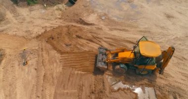 Havadan inşaat alanındaki modern traktör. Büyük sarı traktör. Profesyonel inşaat malzemeleri. İnşaat alanında çalışma süreci