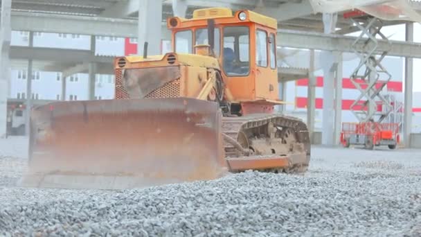 Bulldozer levels the soil. Bulldozer tearing rubble on the ground. Big yellow bulldozer at the construction site. Yellow bulldozer works at a construction site. — Stock Video