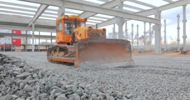 Buldozer toprak katmanını düzleştiriyor. Buldozer inşaat alanında çalışıyor. İnşaat alanında sarı buldozer. İnşaat alanında buldozer. Ağır inşaat ekipmanları
