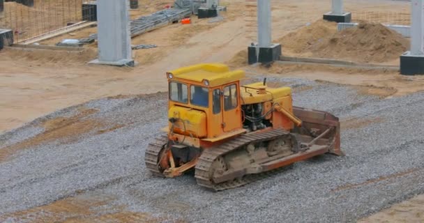 Bulldozer vid byggarbetsplatsen. Gul bulldozer på byggarbetsplatsen. Tung byggutrustning — Stockvideo