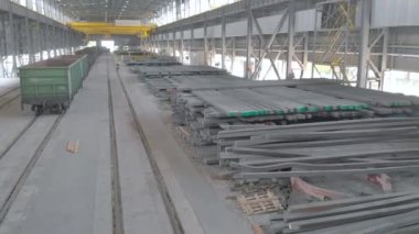 Büyük bir depo, metal kurusıkı ve sarı bir vinç. Bir vinç metal parçaları hareket ettirir. Metal kurusıkı modern bir deponun genel planı