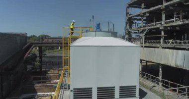 Modern bir soğutma kulesinde mühendis. İşçi soğutma kulesini inceliyor. Modern soğutma kulesine yakın çekim. Modern endüstriyel su soğutma sistemi. Endüstri dışı