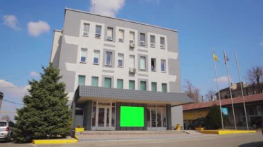 Yeşil ekranlı ofis binası. Reklam pankartı yeşil ekranda. Reklamlarınızı eklemek için yeşil ekranlı bir ofis binası..