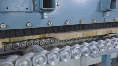 Taşıyıcı hat üzerinde ahşap boşlukları işliyor. Modern üretimde otomatikleştirilmiş üretim hattı