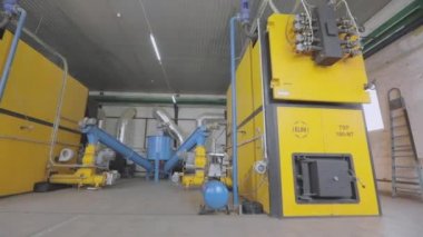 Modern bir ahşap talaş sobası. Fabrikadaki modern bir kazan dairesi. Sanayi ocağı ahşap işçiliğinin atıkları üzerinde çalışıyor. Soba ahşap işçiliğinden gelen atıklarla çalışıyor.