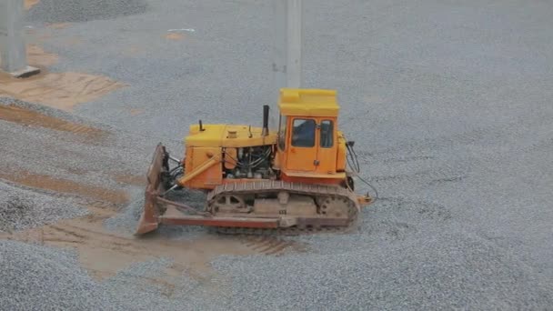 Sarı buldozer inşaat alanında çalışıyor. Buldozer toprak katmanını düzleştiriyor. İnşaat alanında sarı buldozer. İnşaat alanında buldozer. Ağır inşaat ekipmanları — Stok video