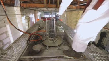 Kamyon tankını kimyasallardan temizliyorum. Kimyasal koruma elbisesi giyen bir işçi.