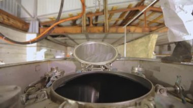 Bir işçi içeriden buharlı bir tank kamyonunun kimyasal temizliğini yapıyor. Tankerin otomatik buhar temizliği. Kimyasal koruma işçisi