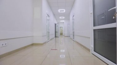 Modern bir hastanenin koridorları. Kamera hastanenin boş koridoru boyunca döner. Kliniğin boş, parlak koridoru. Modern bir kliniğin içinde.