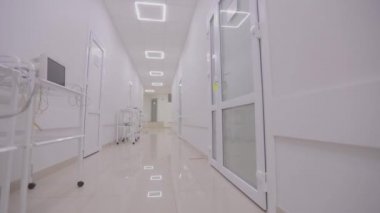 Kamera hastanenin boş koridoru boyunca döner. Modern bir hastanenin koridorları. Kliniğin boş, parlak koridoru. Modern bir kliniğin içinde.