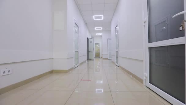 Corredores de un hospital moderno. La cámara pasa por el pasillo vacío del hospital. El pasillo vacío y luminoso de la clínica. Interior de una clínica moderna — Vídeo de stock