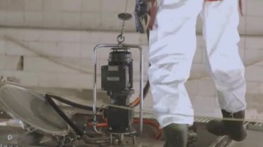 Tankerin otomatik buhar temizliği. Kimyasal koruma işçisi. Bir işçi içeriden buharlı bir tank kamyonunun kimyasal temizliğini yapar..