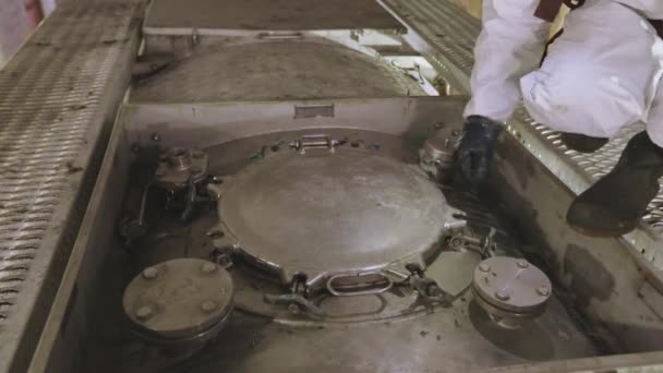 A worker in chemical protection closes the hatch on a truck tank. A worker in a protective suit at a cleaning station. Worker works with hazardous chemicals — Stockvideo