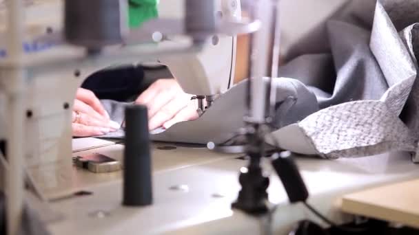 Sprzęt w fabryce włókienniczej. Urządzenia do szycia w fabryce szycia. Zbliżenie procesu szycia w fabryce szycia. — Wideo stockowe