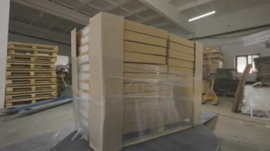 Fabrikadaki plastik filmlerdeki ürünlerin olduğu kutular. Özel bir makine kutuları polietilen filmle sarar