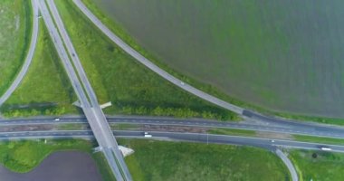 Trafik kavşağı üst görünümü değiştir. Arabalar otoban boyunca gidiyor, manzarası çok güzel. Bir yol kavşağının üzerinden uçuyorlar. Arabalar şehrin dışındaki otoyol boyunca ilerliyorlar.