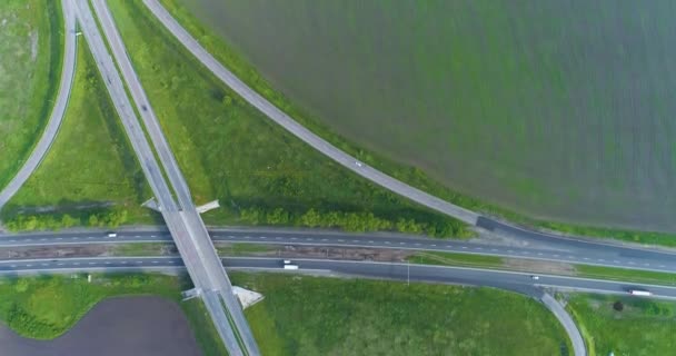 Échange de trafic vue du dessus. Les voitures roulent le long de l'autoroute, vue de dessus. Survoler un carrefour routier Les voitures roulent le long de l'autoroute en dehors de la ville — Video