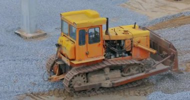 Buldozer toprak katmanını düzleştiriyor. Buldozer inşaat alanında çalışıyor. İnşaat alanında sarı buldozer. İnşaat alanında buldozer. Ağır inşaat ekipmanları