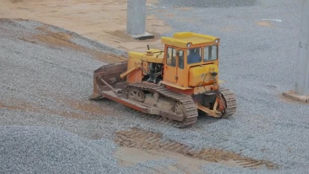 Maszyny budowlane na placu budowy. Ciężki sprzęt budowlany. Żółty buldożer pracuje na budowie. Żółty buldożer na placu budowy. — Wideo stockowe