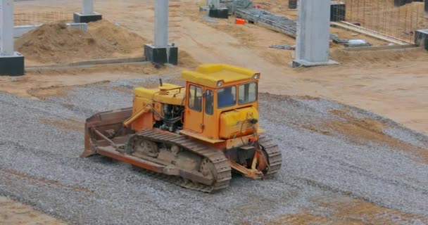 Bulldozer en el sitio de construcción. Buldózer amarillo en el sitio de construcción. Equipos de construcción pesados — Vídeo de stock