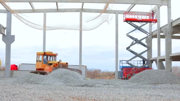 Buldozer srovná půdu se zemí. Buldozer trhá sutiny na zemi. Velký žlutý buldozer na staveništi. Žlutý buldozer pracuje na staveništi. — Stock video