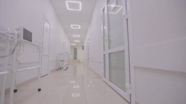 Modern bir kliniğin içinde. Kliniğin boş, parlak koridoru. Modern bir hastanenin koridorları. Kamera hastanenin boş koridoru boyunca dönüyor..